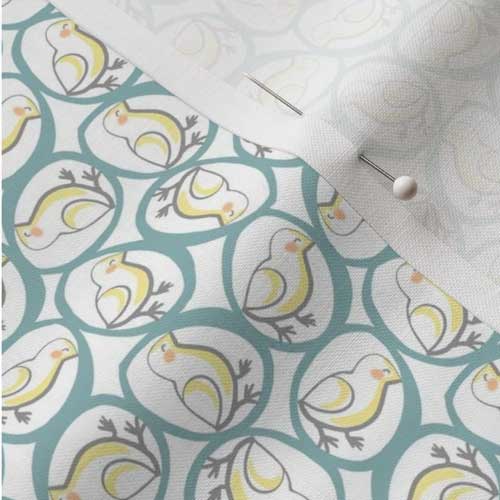 Close up of farmhouse fabric with yellow chicks in teal eggs