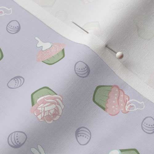 Close up of fabric with Easter cupcakes on light purple