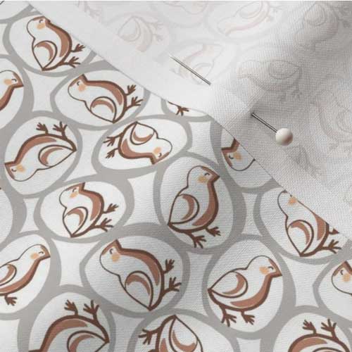 Close up of fabric with chicks in eggs print in earth tones